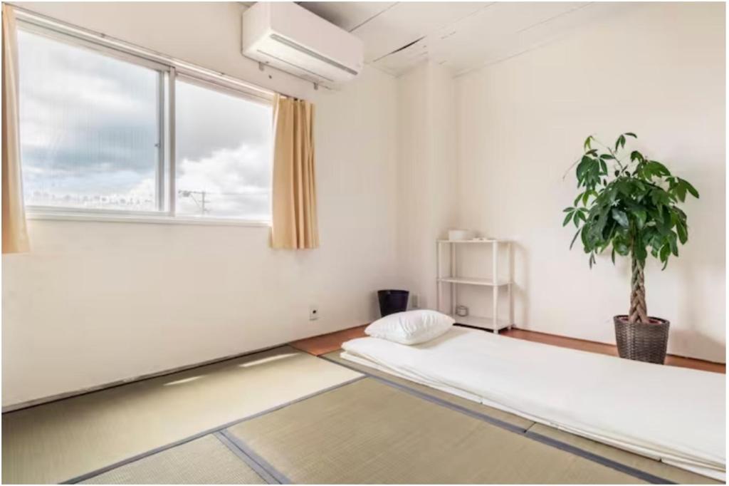um quarto com uma cama e um vaso de plantas em Little Okawood - Vacation STAY 83130v em Ōkawa