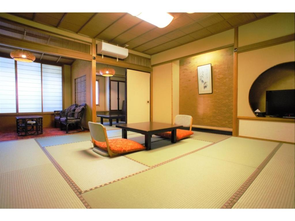 加賀市にあるYamashiro Onsen Yuzankaku - Vacation STAY 86433vのテーブル、椅子、テレビが備わる客室です。