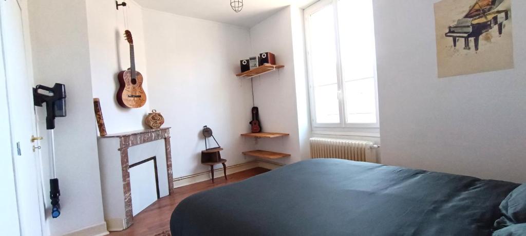 a bedroom with a bed and a fireplace in it at Cœur de Loire in Blois