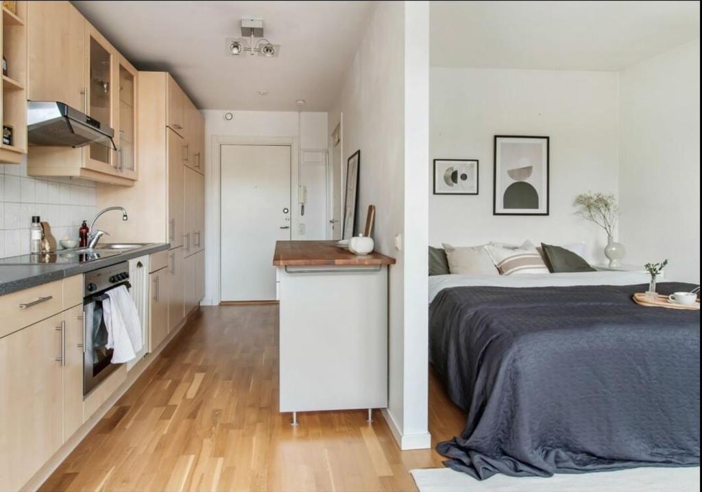a kitchen and a bedroom with a bed and a sink at Cousy and convenient in Västerås