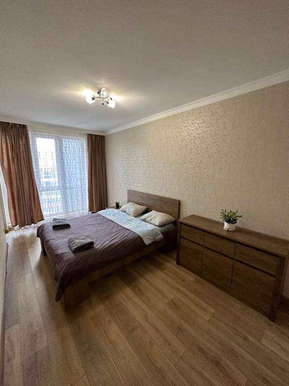 a bedroom with a bed and a large window at Chornovola Apartment Липинського 28 in Lviv