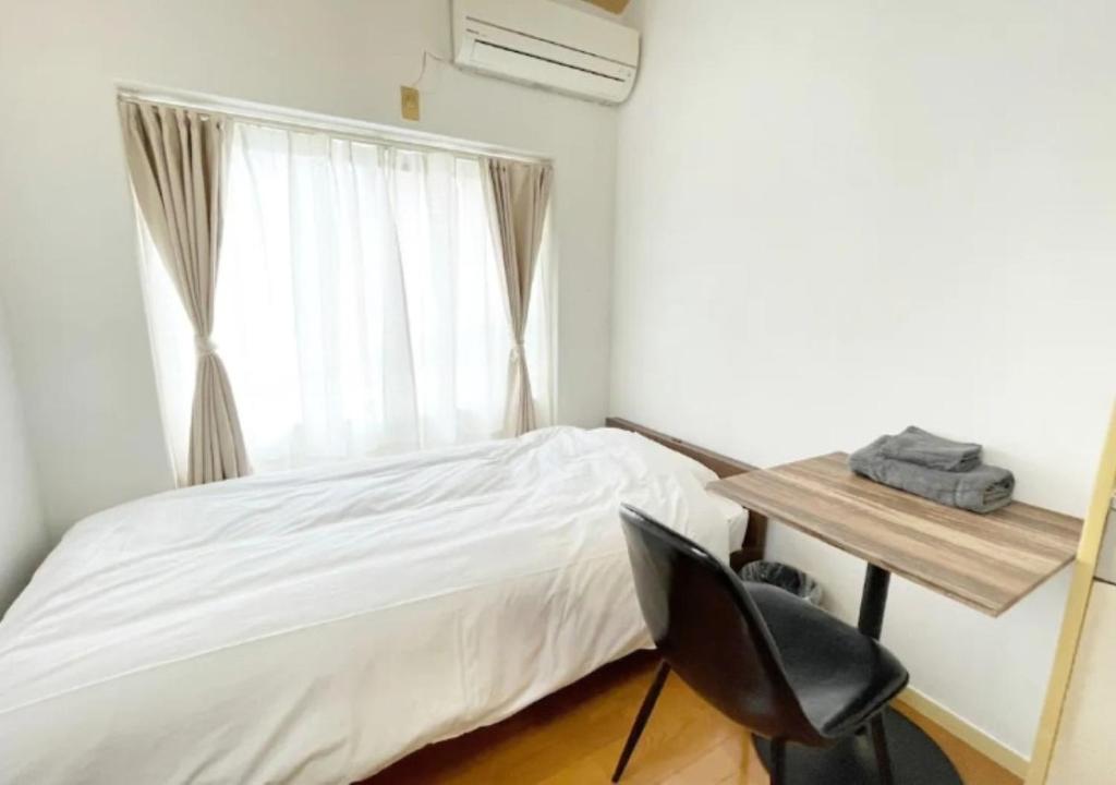a bedroom with a bed and a desk and a window at Beverly Homes Osaki Room 203, Room 205, Room 301, - Vacation STAY 89039v in Tokyo