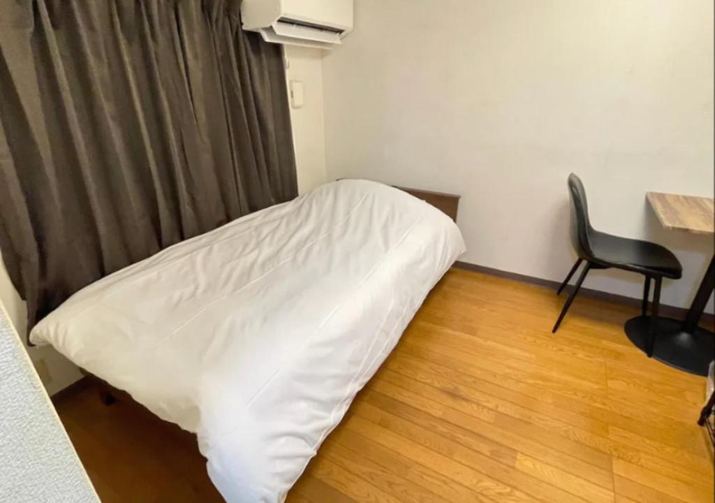 Cama en habitación con escritorio y silla en Beverly Homes Osaki Room 203, Room 205, Room 301, - Vacation STAY 89071v, en Tokio