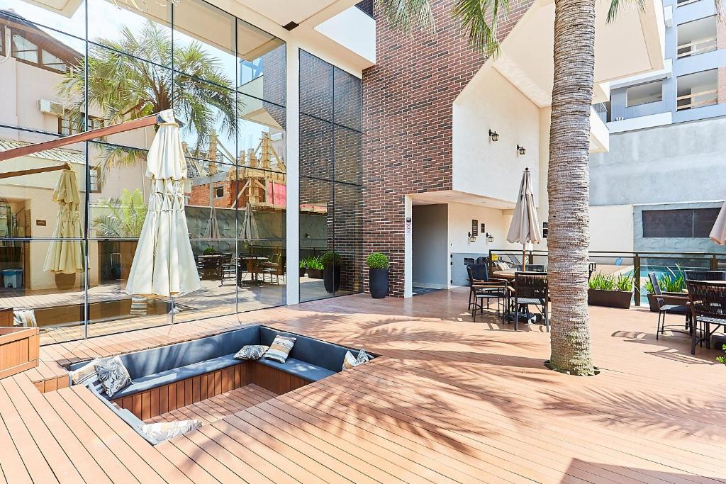 a patio with a couch and a table and a building at 1108 -Lindo e completo apto com piscina na Praia de Bombas in Bombinhas