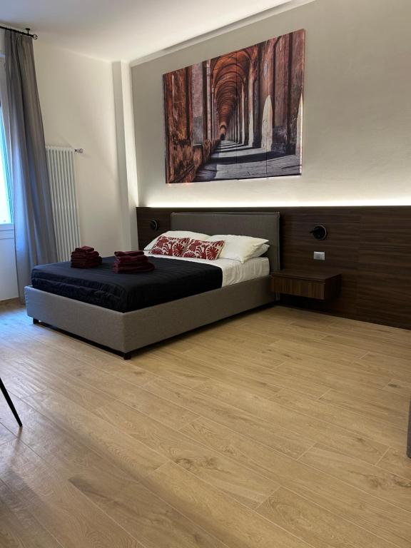 ボローニャにあるALBARI HOUSEのベッドルーム1室(ベッド1台付)が備わります。壁には絵画が飾られています。