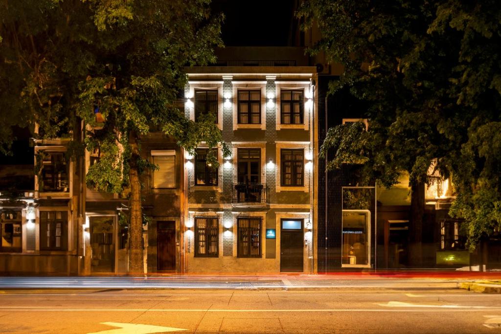 een gebouw met 's nachts lichten aan de voorkant bij AVUS M Suites and Apartments by DA'HOME in Porto