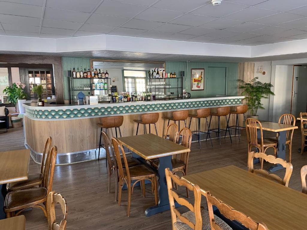 ein Restaurant mit Tischen und Stühlen und eine Bar in der Unterkunft Le Grand Hôtel Ussel ''nouvelle Gérance 2023'' in Ussel