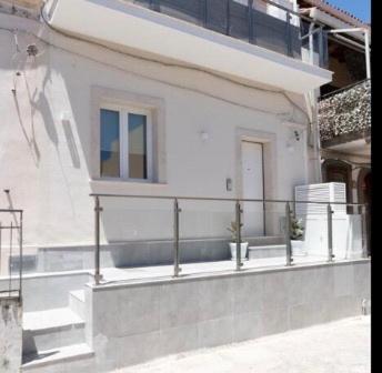 Edificio blanco con balcón y puerta en Venti di Brucoli, en Brucoli