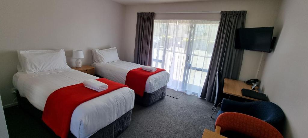 una camera d'albergo con due letti e una finestra di Riccarton Mall Motel a Christchurch