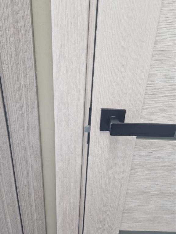 einem Schließen einer Holztür mit schwarzem Griff in der Unterkunft Luxury apartment in city center in Narva
