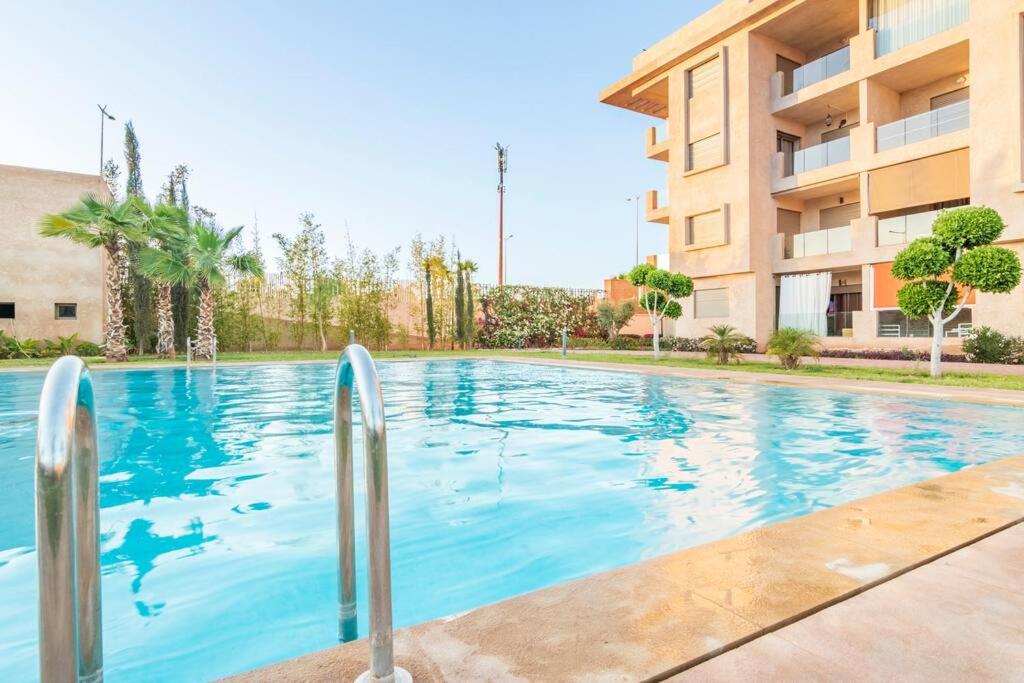 une piscine en face d'un bâtiment dans l'établissement Luxury Apartment Les perles de Marrakech, à Marrakech