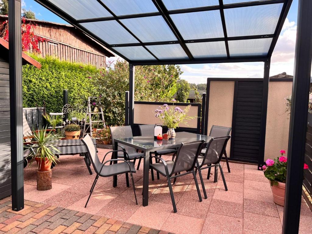 a patio with a black pergola and a table and chairs at Ferienwohnung Leopold in Tschernitz