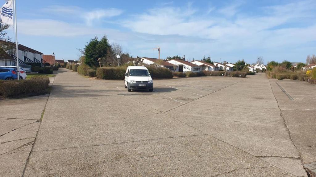 ein weißes Auto parkt auf einem Parkplatz in der Unterkunft Vacances relax à Bredene in Bredene