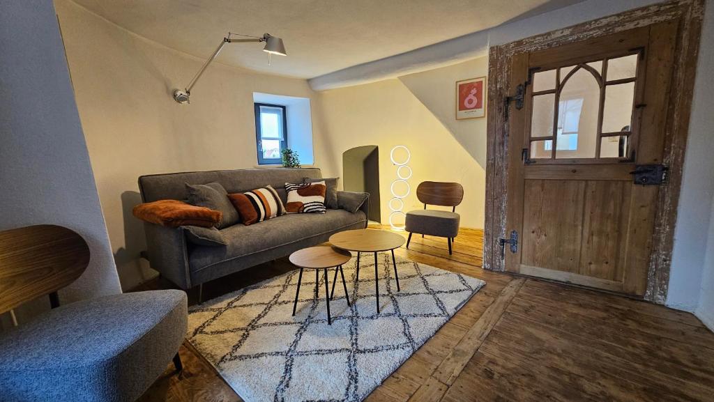 uma sala de estar com um sofá e uma mesa em YFB l 500 Jahre alter Stadtmauerturm em Dillingen an der Donau