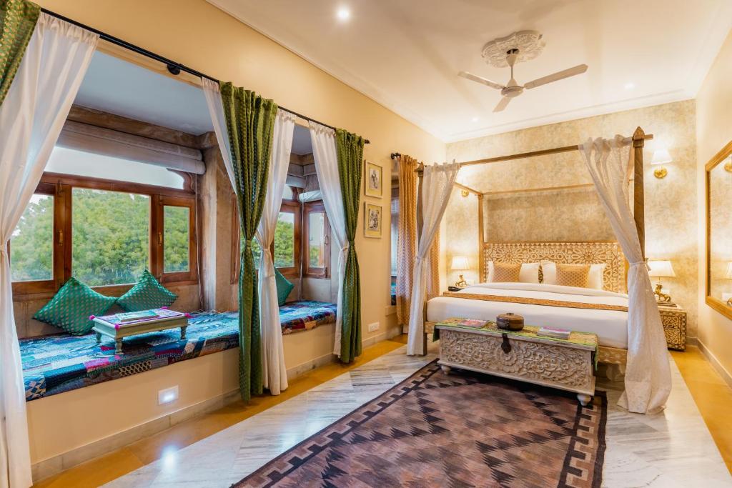 a bedroom with two beds and a large window at Hotel Jasmin Home in Jaisalmer