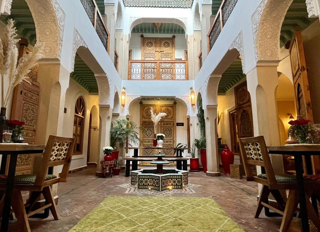 a room with a table and chairs in a building at Riad Dar Fanny in Marrakesh
