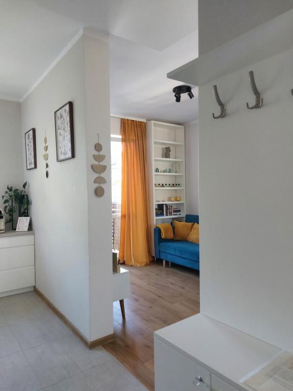 a living room with white walls and a blue couch at Apartamencik przy Tężni w Konstancinie in Konstancin-Jeziorna