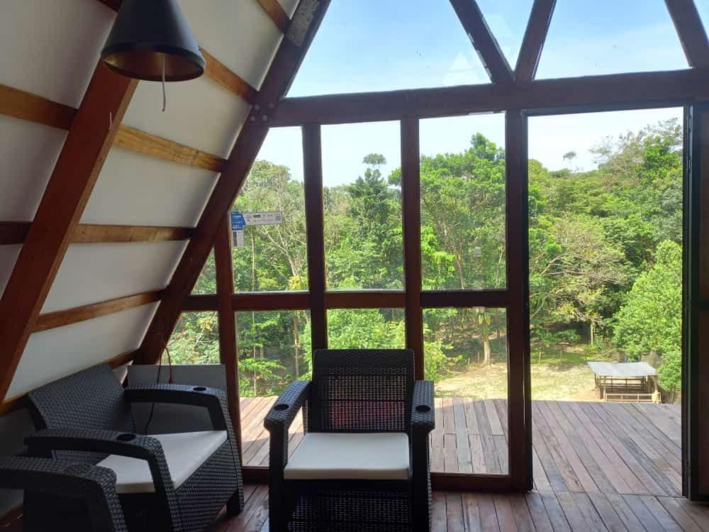 eine abgeschirmte Veranda mit Stühlen und einem großen Fenster in der Unterkunft Glamping RanchoEmilio in Villavicencio