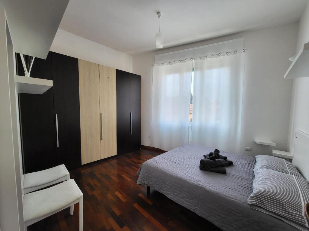 um quarto com uma cama, uma cadeira e uma janela em White Home Forli Centro em Forlì