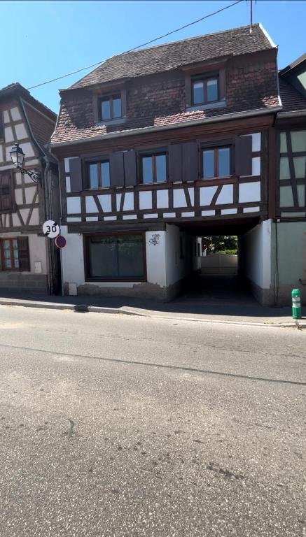 a brown and white building on the side of a street at La Vitrine in Gertwiller