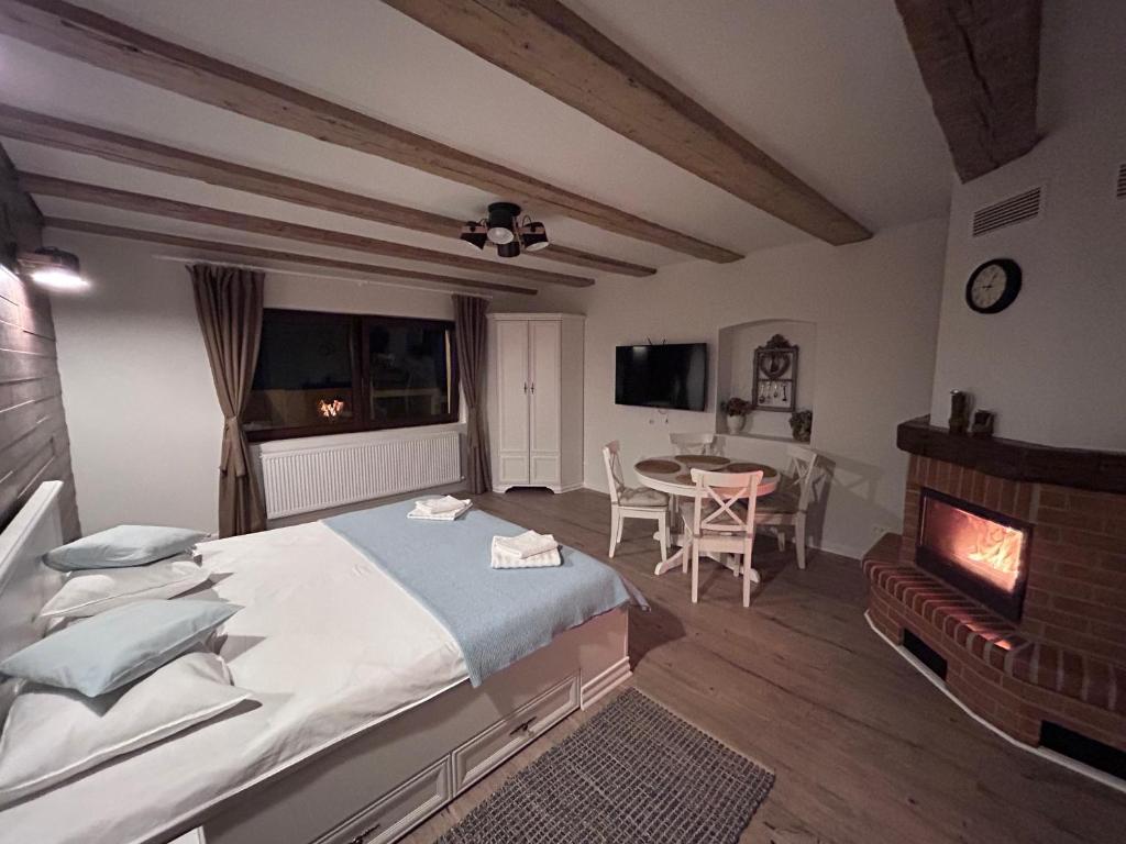 Schlafzimmer mit einem Bett, einem Tisch und einem Kamin in der Unterkunft Studio Alexandra in Săcele