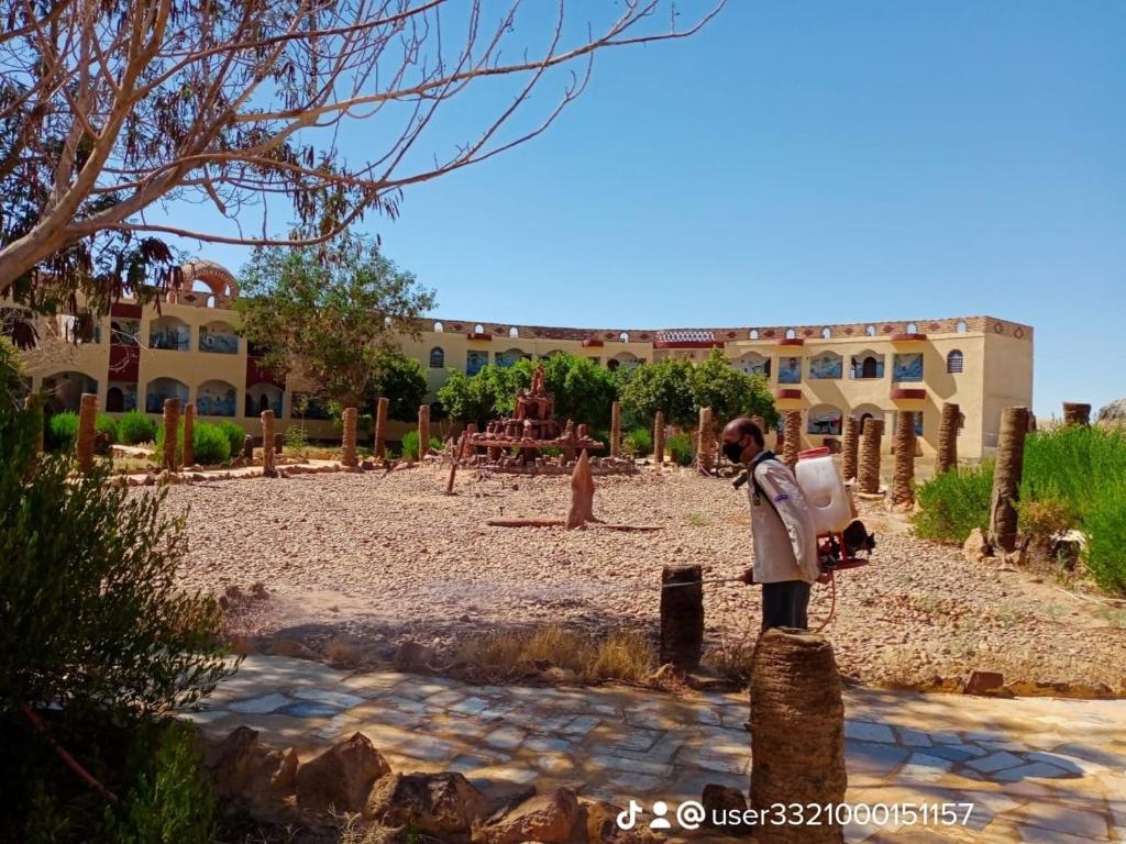 a man standing in front of a building at Oasis Panorama Hotel in Bawiti