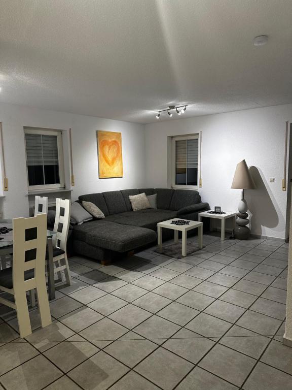 - un salon avec un canapé, une table et des chaises dans l'établissement 1 Zimmer Apartment, à Klettgau