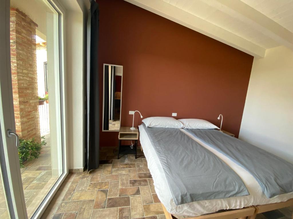 a bed in a bedroom with a wall at Fuoridicampo beige in Roncovetro