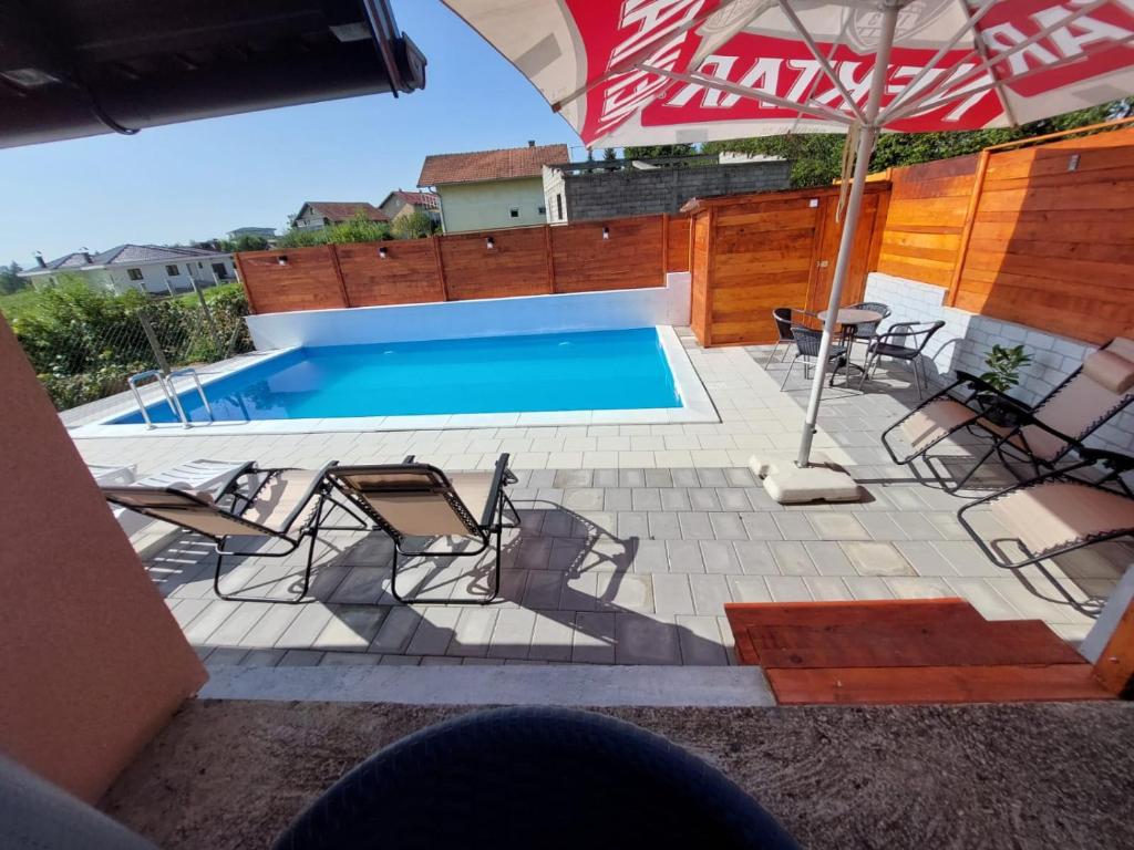 - une piscine avec des chaises et un parasol dans l'établissement Vikendica Krčmarice, à Banja Luka
