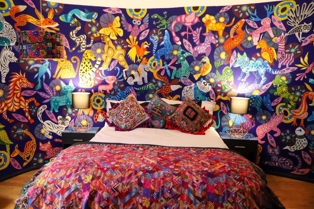 um quarto com uma parede colorida e uma cama em The Tower of Alebrijes in San Angel Inn em Cidade do México
