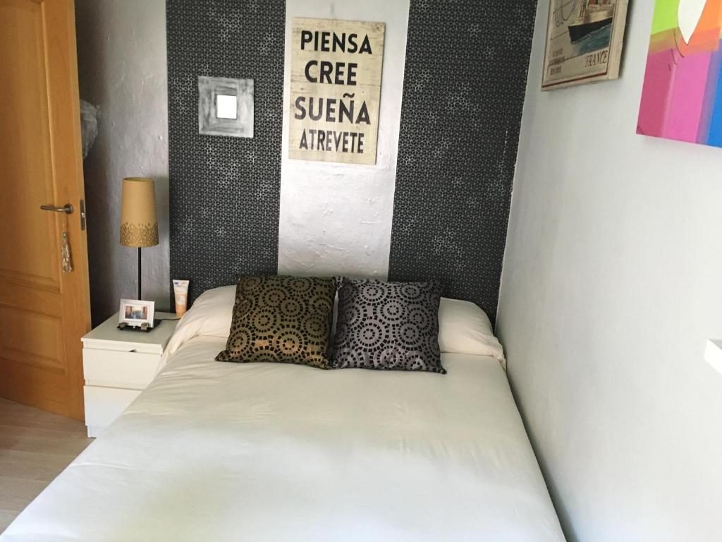 a bed with two pillows on it in a bedroom at Habitación particular,baño compartido in Zaragoza