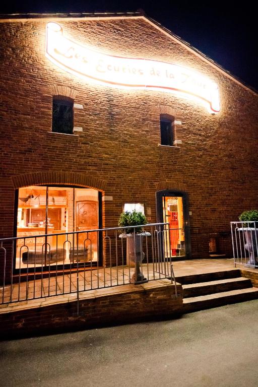 un magasin devant un bâtiment en briques la nuit dans l'établissement Les Ecuries de la Tour, à Mondonville
