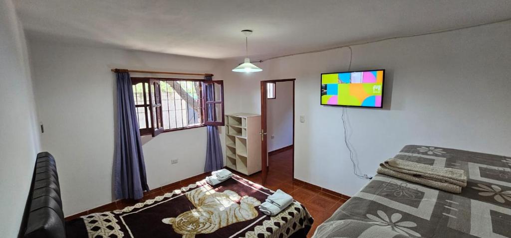a living room with a couch and a tv on the wall at Hospedaje Resiliencia in Cordoba