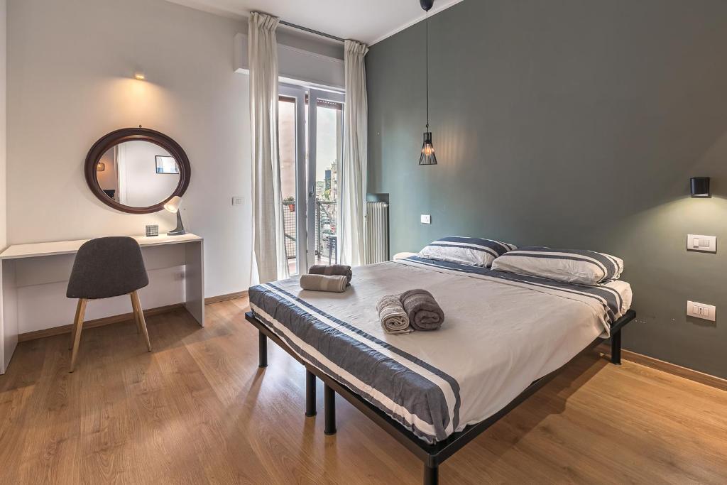 Schlafzimmer mit einem Bett mit einem Spiegel und einem Schreibtisch in der Unterkunft Max's House in Mailand