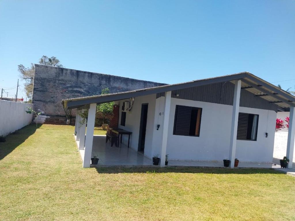 a small white house with a table in a yard at Casa disponível para diária, 300m do mar casa sozinha no terreno in Matinhos