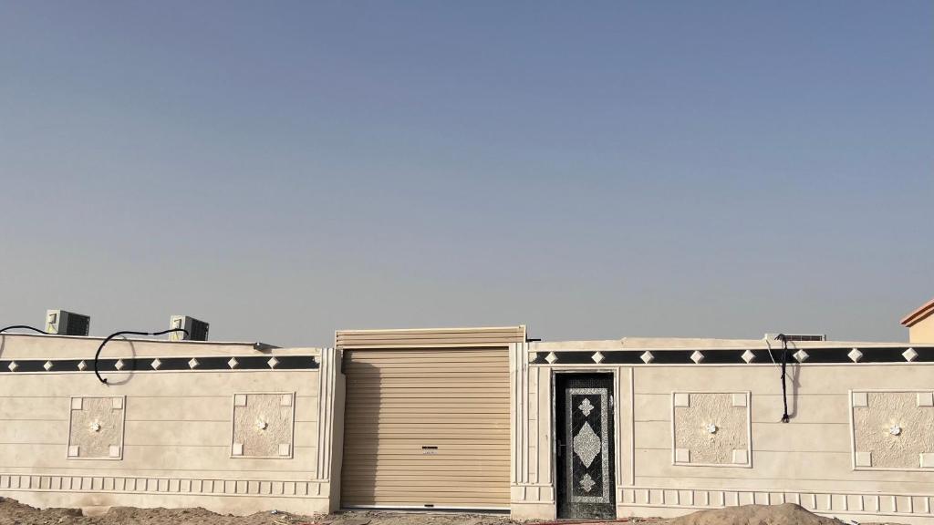a building with two garage doors on the side of it at استراحة النود in Al Nairyah