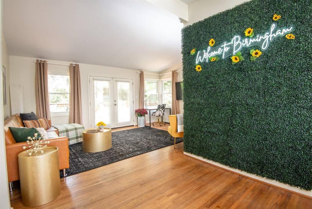 a living room with a green wall with sunflowers at Serenity on Montclair - Groups/Games/FastWiFi in Birmingham