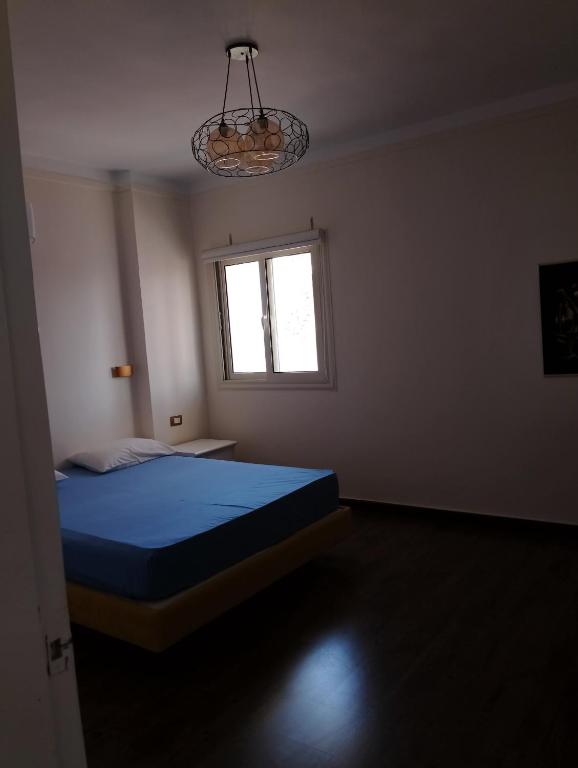 ein Schlafzimmer mit einem blauen Bett und einem Fenster in der Unterkunft Chalet on the beach in Hurghada