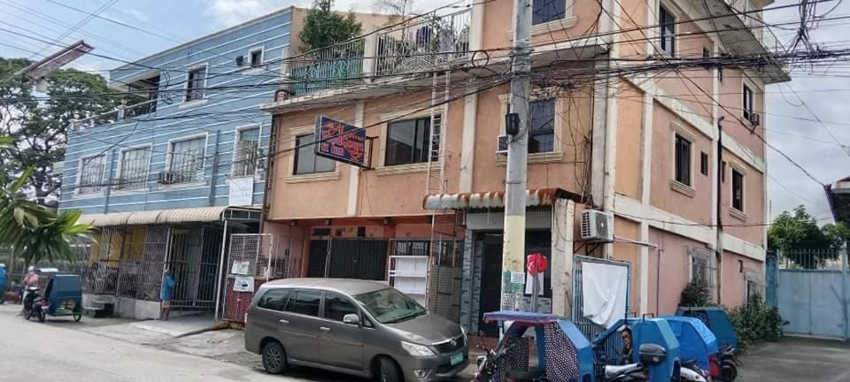 un'auto parcheggiata davanti a un edificio di Aladino Hostel a Dasmariñas