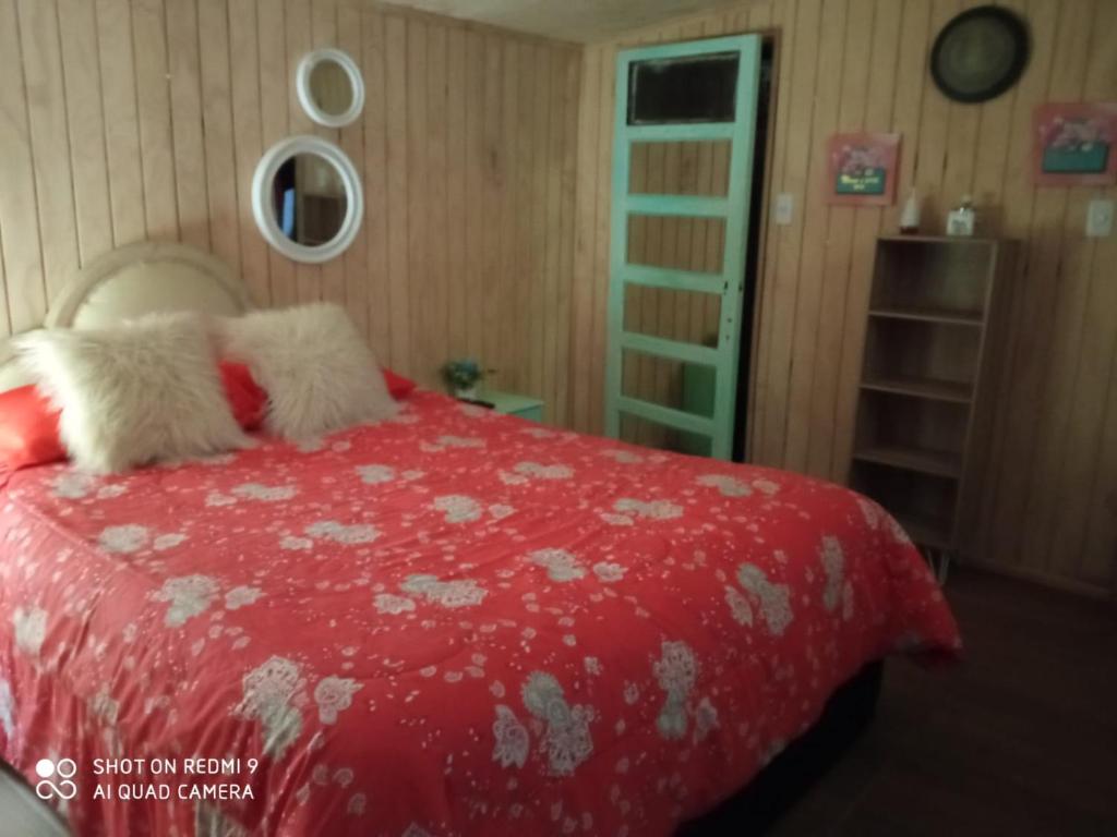 a bedroom with a red bed with two pillows at Hostal¤ Familiar¤ in Chillán