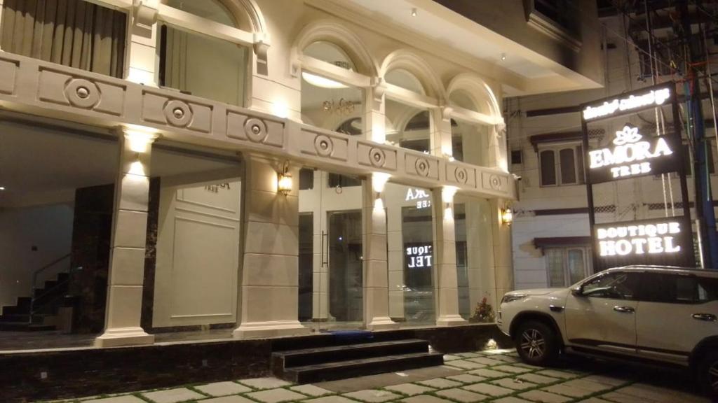 a car parked in front of a building at night at Hotel Emora Tree in Mysore