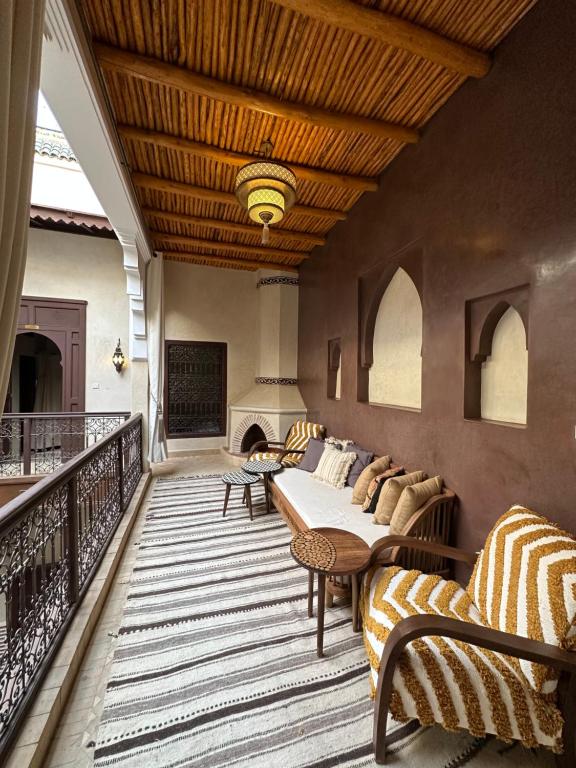 a balcony with a couch and a table and a fireplace at Riad Sakura Marrakech in Marrakesh