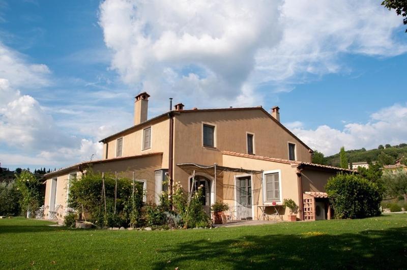 una grande casa in un campo con un cortile verde di Villa Danilo by PosarelliVillas a San Casciano dei Bagni