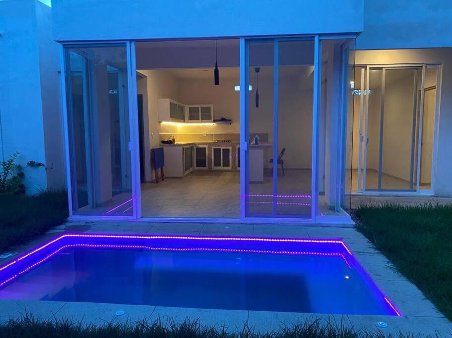 庫埃納瓦卡的住宿－Casa con Tina de Hidromasaje Climatizada，一座带紫色灯光游泳池的房子