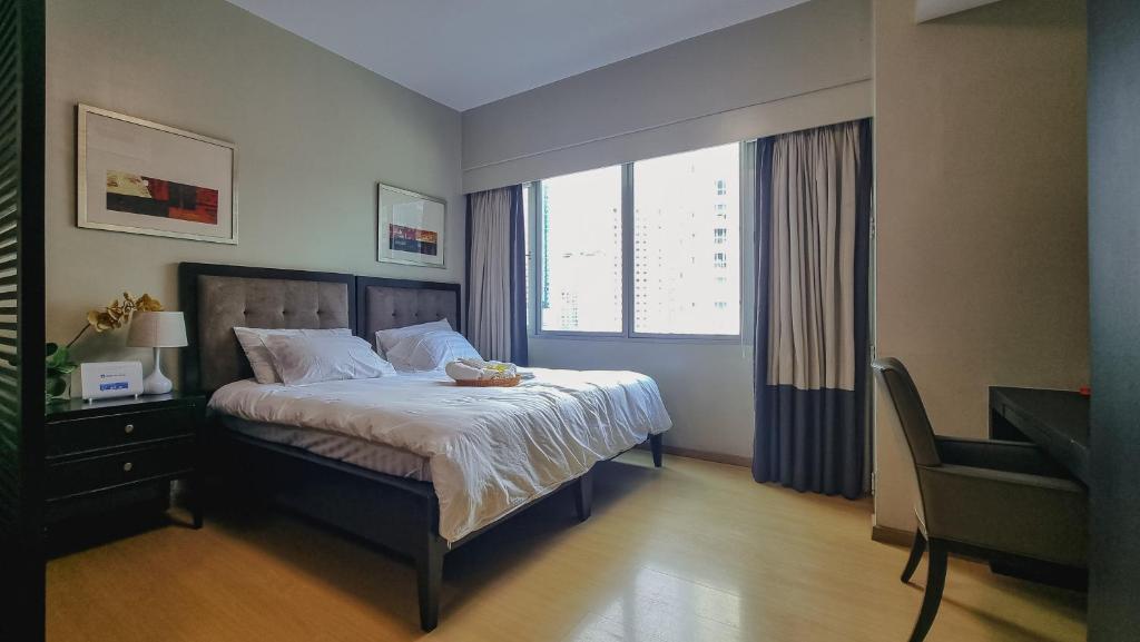 um quarto com uma cama, uma secretária e uma janela em Hotel like unit The Avant at the Fort em Manila