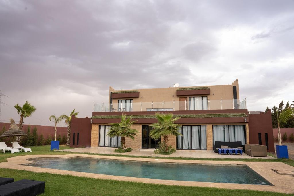 una casa con piscina frente a ella en VILLA MYAD en Marrakech