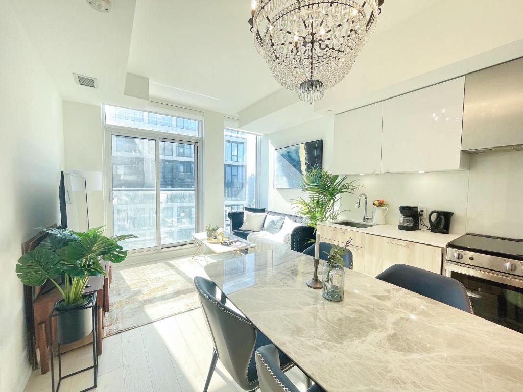 uma cozinha e sala de estar com mesa e cadeiras em INFIVILLA Amazing Penthouse Living in Sunrise- Breathtaking Skyline Lake View Downtown Toronto!A em Toronto