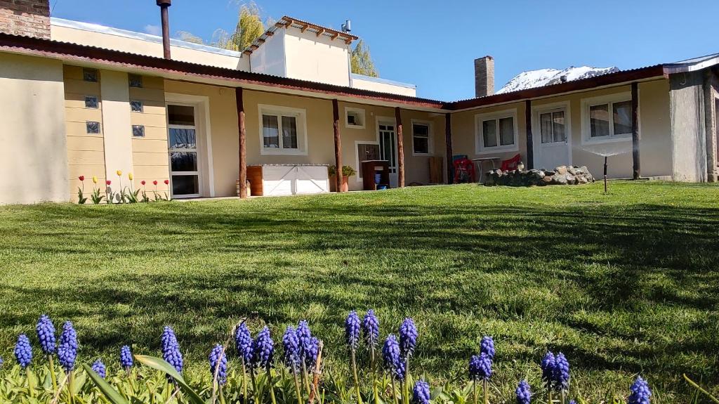 a house with purple flowers in the yard at El viejo boliche in Trevelin