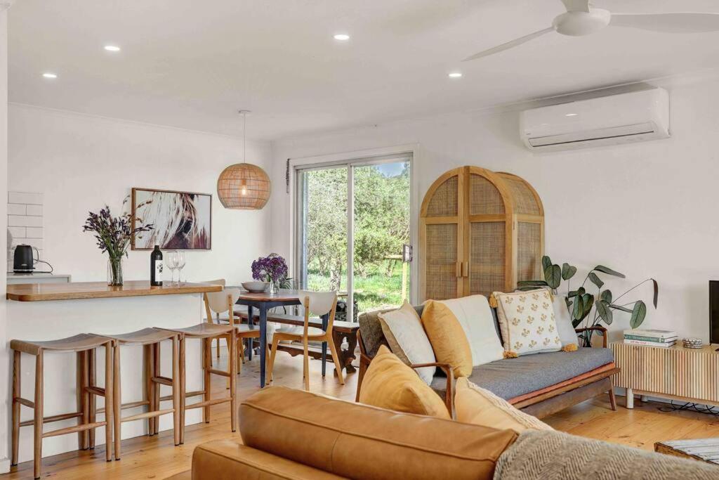 a living room with a couch and a table at Whimsical Willunga Getaway in Willunga