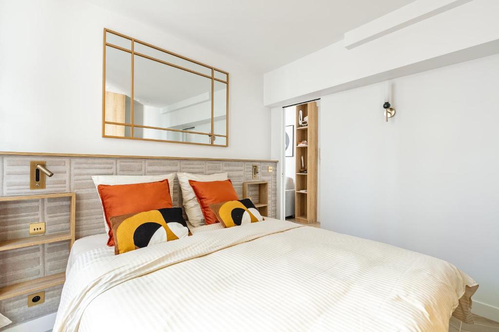 une chambre avec un grand lit avec un miroir au mur dans l'établissement La Suite du Marais, à Paris